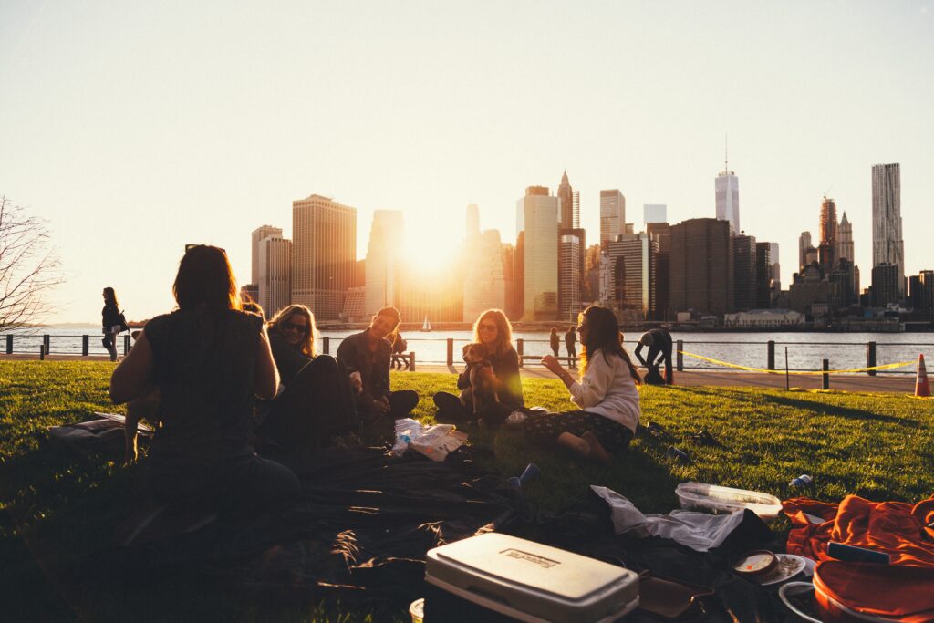 How to have better fluency with great rhythm in English. Friends sit in the park and talk in a big city.